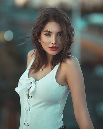 Stunning outdoor portrait of a brunette fashion model with red lips in a stylish white outfit. HD phone wallpaper