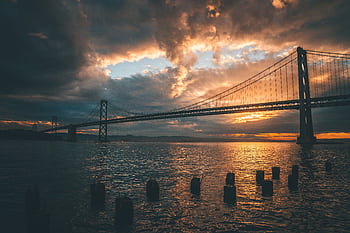 Stunning sunset view of the Bay Bridge in San Francisco reflecting on water. HD wallpaper