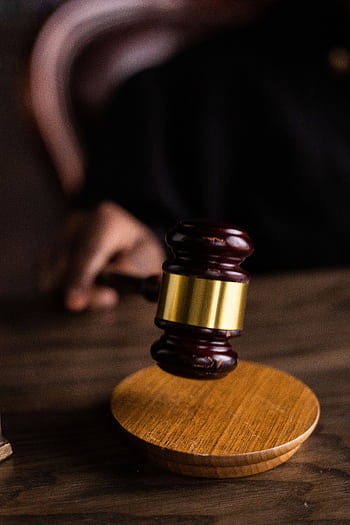 Close-up of a judge's gavel on a wooden block, symbolizing justice and law. HD phone wallpaper