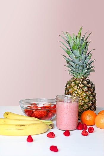 A vibrant smoothie with pineapple, banana, and berries, showcasing healthy freshness. HD phone wallpaper