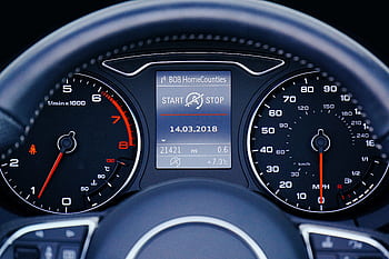 Close-up of a car dashboard displaying speedometer, tachometer, and digital display with mileage. HD wallpaper