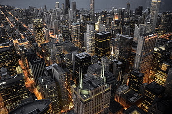 Explore the vibrant skyline of Chicago with its illuminated skyscrapers and bustling urban life captured at dusk. HD wallpaper