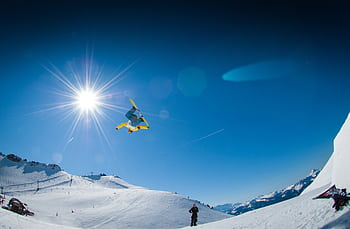 Snowboarder executing a style trick in the sunny winter Alps. HD wallpaper