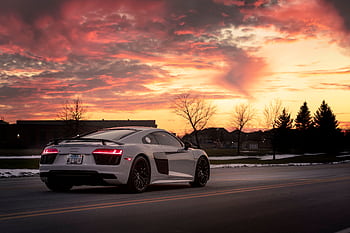 Stylish Audi R8 sports car on suburban road against a vibrant sunset in Chicago. HD wallpaper
