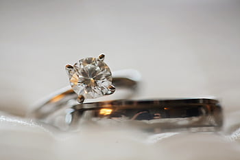 Elegant macro shot of a diamond engagement ring set with a blurred background. HD wallpaper