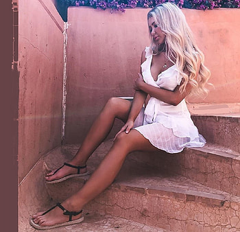 ANDREANE CHAMBERLAND, white mini dress, sandals, platinum blonde, pink walls, sitting on stairs, jewelry HD wallpaper