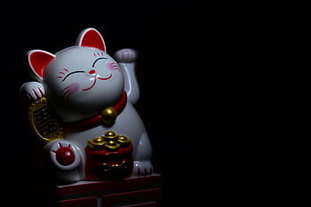 A ceramic Maneki Neko, or lucky cat, figurine symbolizing good fortune, with a dark background. HD wallpaper