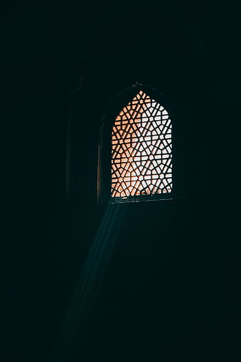 Sunlight streaming through a Mughal-style window in Agra, showcasing intricate Islamic architectural patterns. HD phone wallpaper