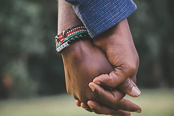 A close-up view of a couple holding hands, symbolizing love and togetherness. HD wallpaper