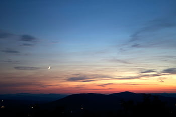 Peaceful twilight skyscape with a crescent moon over distant hills. HD wallpaper