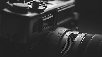 Detailed monochrome close-up of a vintage camera lens, highlighting aperture settings and classic design. HD wallpaper