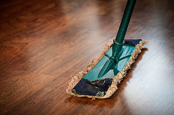 A detailed view of a mop cleaning a wooden floor, showing texture and pattern. HD wallpaper