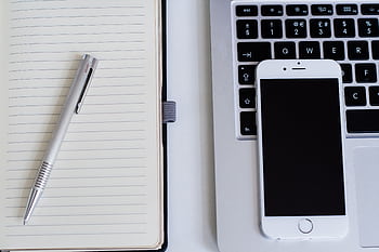 Close-up of a notebook, pen, smart, and laptop on a modern workspace. HD wallpaper