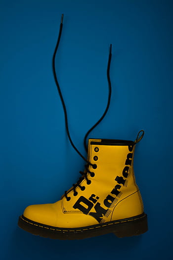 Eye-catching yellow Dr. Martens boot with laces on a bold blue background. HD phone wallpaper