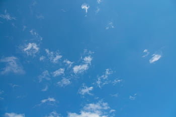 Bright blue sky with scattered fluffy white clouds creating a serene atmosphere. HD wallpaper