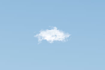 A lone white cloud floats peacefully in a clear blue sky, ideal for backgrounds. HD wallpaper