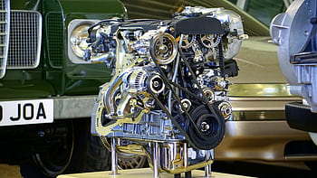 Detailed view of a polished car engine in an exhibition setting. HD wallpaper