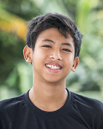 Happy Asian boy smiling in outdoor setting, capturing joy and innocence. HD phone wallpaper