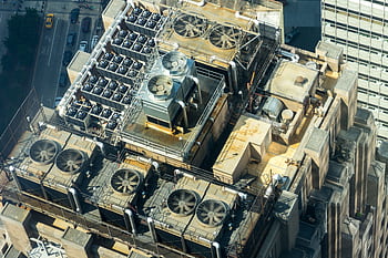 High-angle shot of HVAC units on a city building's rooftop, showcasing industrial infrastructure. HD wallpaper