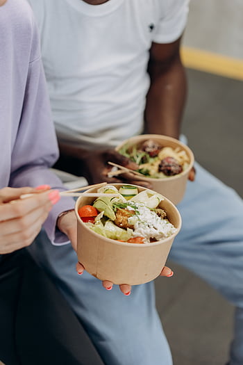 Two people enjoying nutritious salad bowls with fresh ingredients indoors. HD phone wallpaper