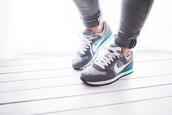 Stylish Nike sneakers on a wooden floor, perfect for jogging and fitness activities. HD wallpaper