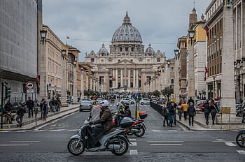 St. Peter's Basilica view with vibrant street life, Rome. HD wallpaper