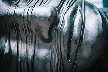 Close-up view of a textured metallic sculpture emphasizing patterns and reflections. HD wallpaper