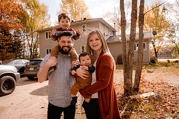 Smiling family of four enjoying a sunny autumn day in their backyard. HD wallpaper