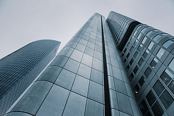 Low angle view of modern skyscrapers with glass and steel design. Perfect for corporate ry. HD wallpaper