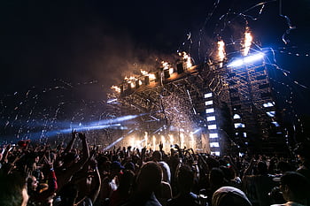 Vibrant concert scene with crowd enjoying night festival and dynamic stage fireworks. HD wallpaper