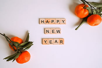 Happy New Year message with Scrabble tiles and fresh mandarins for festive decor. HD wallpaper