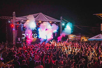 Lively outdoor music festival with vibrant lights, crowd energy, and a dynamic performance. HD wallpaper
