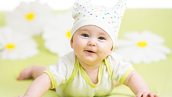 Cute Boy Toddler Is Lying Down On Green Cloth Wearing Light Green White Dress And Cap Cute HD wallpaper
