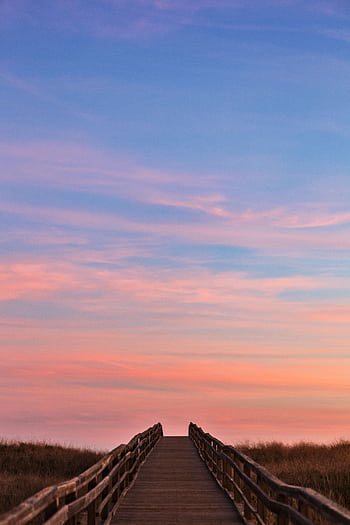 Captivating sunset over a coastal boardwalk leading into the horizon in Lagos, Portugal. HD phone wallpaper