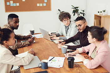 A diverse group of professionals engaged in a collaborative team meeting at the workplace. HD wallpaper