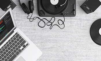 Flat lay of a music workspace with a laptop, heads, turntable, and speakers on a desk. HD wallpaper