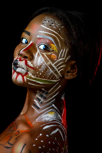 Close-up portrait of a woman with vivid body paint on a black background. HD phone wallpaper