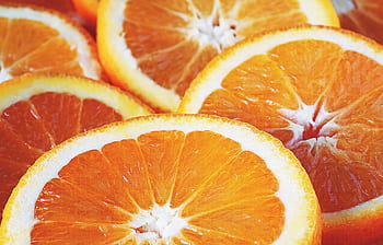 Vivid close-up of freshly sliced oranges showcasing vibrant colors and freshness. HD wallpaper