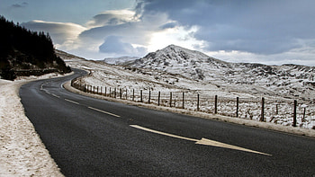 blacktop highway coming down a mountain in winter, winter, fence, clouds, mountains, highway, blacktop HD wallpaper