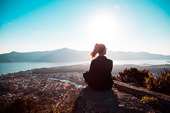 A person enjoying a tranquil mountain view at sunset, reflecting solitude. HD wallpaper