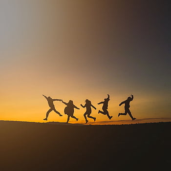 Group of friends jumping joyfully during sunset in Iceland, symbolizing dom and happiness. HD phone wallpaper