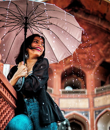 A cheerful woman with an umbrella enjoys the rain in New Delhi's architectural beauty. HD phone wallpaper