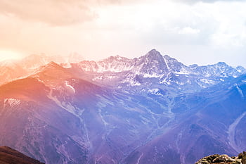 Breathtaking view of snow-covered mountains at sunrise with a vibrant sky. HD wallpaper