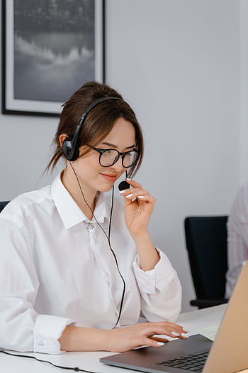 Professional woman using headset for customer service in office setting. HD phone wallpaper