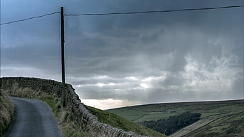 stone wall along a hill road r, electric pole, clouds, wall, road, r, hill, stones HD wallpaper