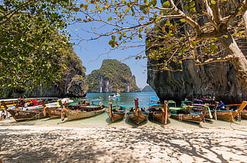 Idyllic beach scene with boats docked at Krabi, Thailand, and beautiful rock formations. HD wallpaper