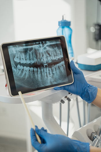 Dentist displaying dental x-ray on tablet in a modern clinic. HD phone wallpaper