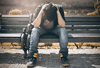 Man sitting alone on a bench in Agra, displaying signs of stress and loneliness. HD wallpaper