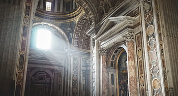 A majestic view of a cathedral's ornate interior with sunrays illuminating the columns. HD wallpaper