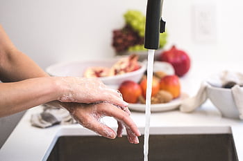 Hands washing with soap under faucet, emphasizing cleanliness and hygiene. HD wallpaper